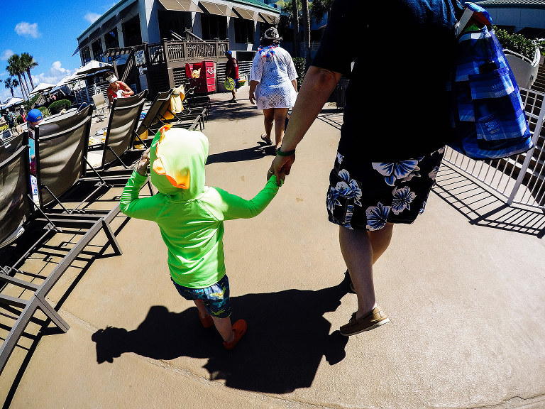father son holding hands walking