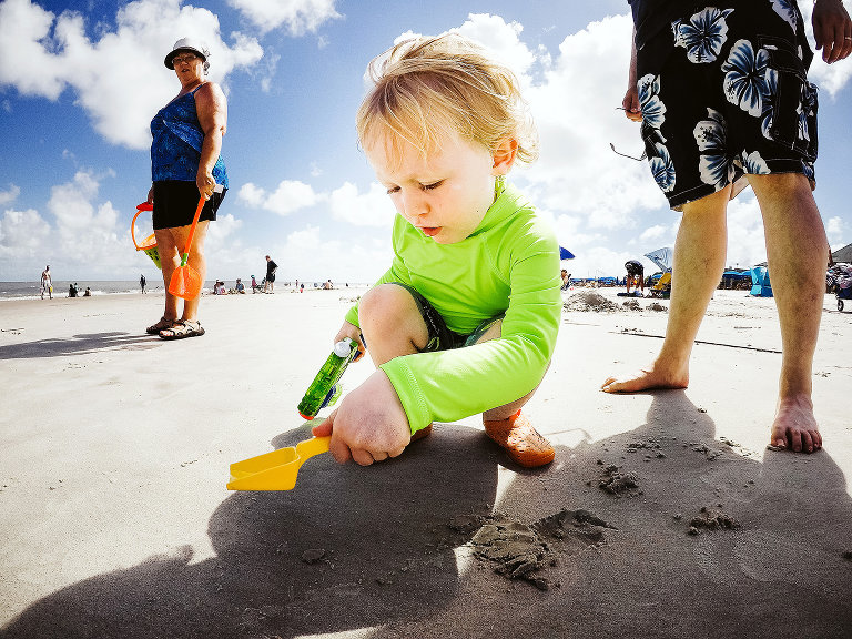 little boy playing in sand