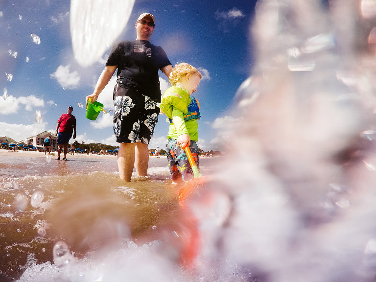 father and son playing in waves