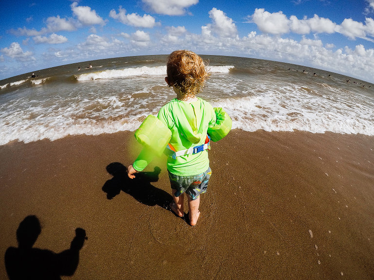 little boy walking to ocean