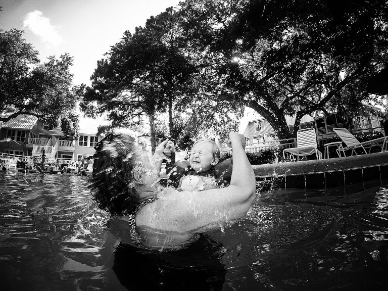 boy splashing grandma in pool